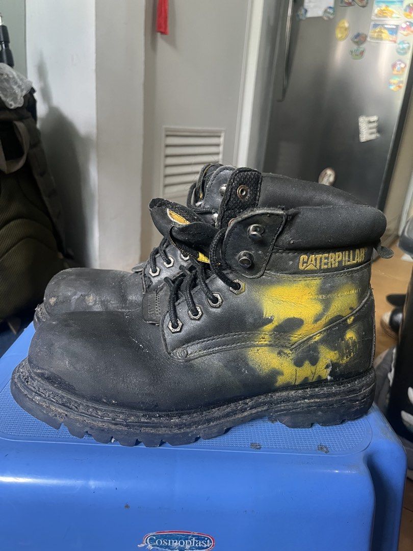 Caterpillar Black Work Boots (Category: Boots) located in Marikina City. Submitted by baron0923 (Listing ID 1468453980, Image 2). Description: - Brand: Caterpillar (CAT) - Color: Black with yellow paint splatters and iconic yellow logos - Style: Heavy-duty work boots with lace-up closure, metal eyelets, and speed hooks - Features: Sturdy build, thick lug soles, and comfortable padded collars - Condition: Heavy wear with visible dirt and scuffs ac