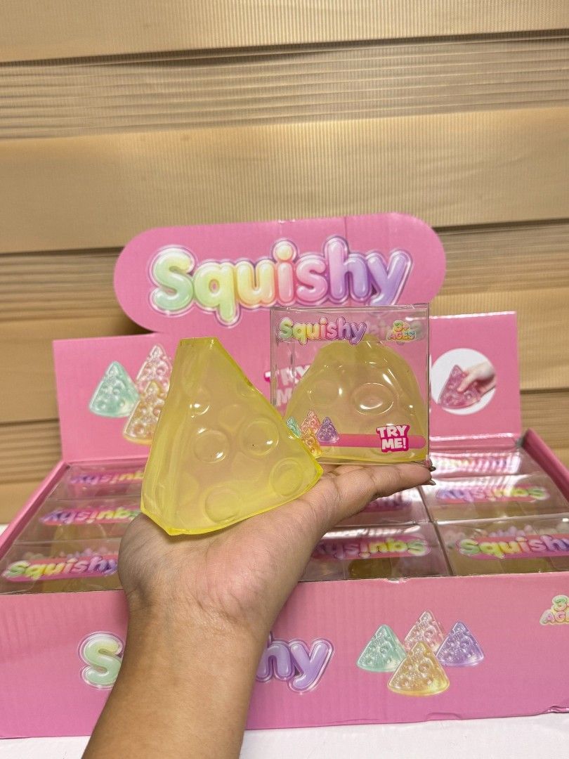 Cheese Slice Shaped Squishy Toy Soft Stress Relief (Category: Kids Toys) located in Pasay City. Submitted by clotheslinemanila (Listing ID 1468455298, Image 2). Description: - Cute triangle cheese-shaped design in bright yellow - Super soft texture for ultimate stress relief and fidgeting - Fun tactile experience with textured cheese holes - Individually packed in a clear box inside a display stand - Perfect gift or desk accessory.
