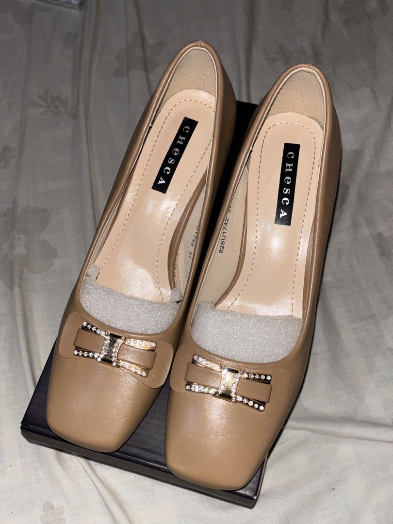 Chesca Block Heel Pumps Size 37 Nude (Category: Heels) located in Manila. Submitted by ernndlcrzl72179 (Listing ID 1468351280, Image 1). Description: Chesca block heel pumps in nude beige. Size 37. Square toe design with rhinestone embellished bow detail on the front. Chunky block heel for comfortable walking. Original shoe box included inside. Packing foam still stuffed inside the shoes. Clean insoles and pristine outer material. Wore it once, I