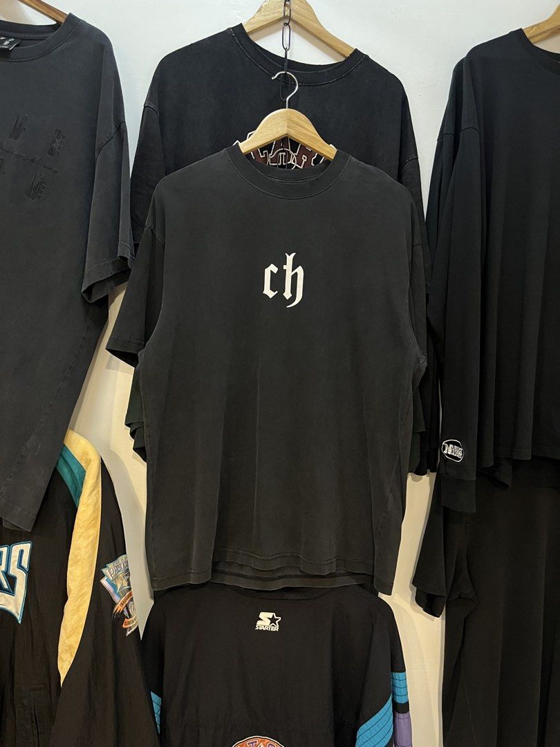 Chinism Black Gothic Ch Logo Tee (Category: Tshirts & Polo Shirts ) located in Manila. Submitted by thriftniking (Listing ID 1468466048, Image 1). Description: Chinism Dimes: 24x29 Excellent condition Color Color rate 9/10 Mop: gcash/maribank Mop: jnt/lalamoved Black short sleeve t-shirt from chinism. Large white gothic ch logo print on the chest. Classic crew neckline and straight hem. 100 percent cotton fabric with a washed vintage look. Interi