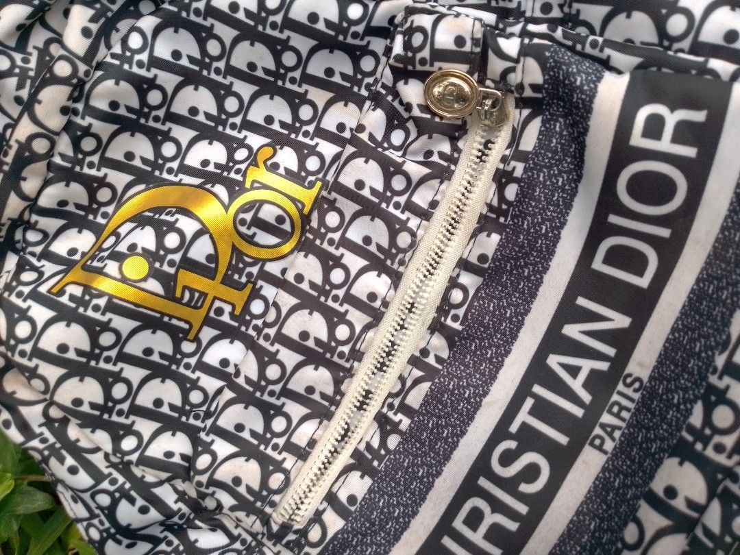 Christian Dior Monogram Backpack Black and White (Category: Backpacks) located in Tabaco. Submitted by cuniie (Listing ID 1468349945, Image 3). Description: - Brand: Christian Dior - Design: Classic black and white monogram with white vertical 'Christian Dior Paris' band - Hardware: Gold CD logo on the front pocket; metal buckles have signs of rust - Compartments: Convenient front zip pocket - Straps: Adjustable black shoulder straps with branded