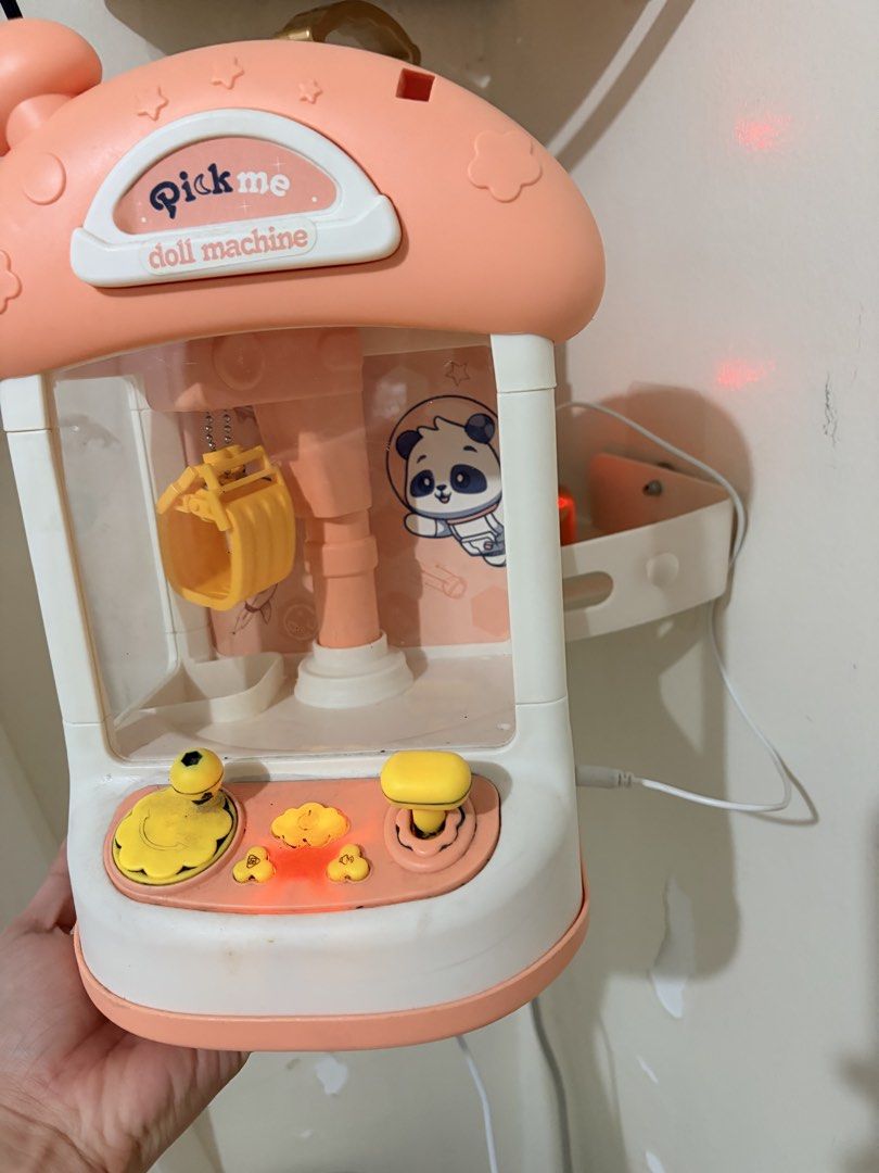 Claw Machine (Category: Kids Toys) located in Makati City. Submitted by makatigirlpreloved (Listing ID 1468377995, Image 2). Description: - Color: Pink and white with an adorable panda astronaut graphic inside - Controls: Fun yellow joystick and interactive buttons - Power: Convenient USB power cable included (plugs into side port) - Perfect for: Hours of entertainment grabbing small toys and prizes - Condition: Brand new and ready for playtime f