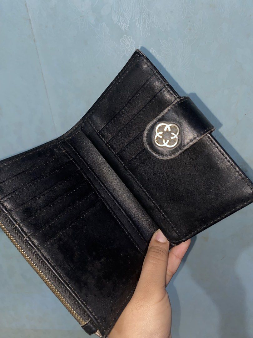 CLN Monogram Medium/Bifold Wallet (Category: Wallets & Card holders) located in Pasig City. Submitted by six_seven67 (Listing ID 1468378663, Image 2). Description: - Stylish black and brown patterned design with a snap button closure and metallic logo detail - Smooth black leather interior lining - Multiple card slots and spacious bill compartments - Convenient clear ID window - Side zippered pocket for coins - Compact size that fits easily into 