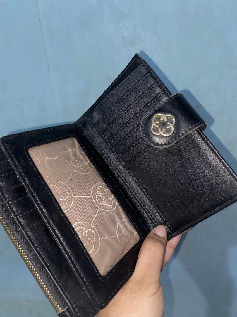 CLN Monogram Medium/Bifold Wallet (Category: Wallets & Card holders) located in Pasig City. Submitted by six_seven67 (Listing ID 1468378663, Image 3). Description: - Stylish black and brown patterned design with a snap button closure and metallic logo detail - Smooth black leather interior lining - Multiple card slots and spacious bill compartments - Convenient clear ID window - Side zippered pocket for coins - Compact size that fits easily into 