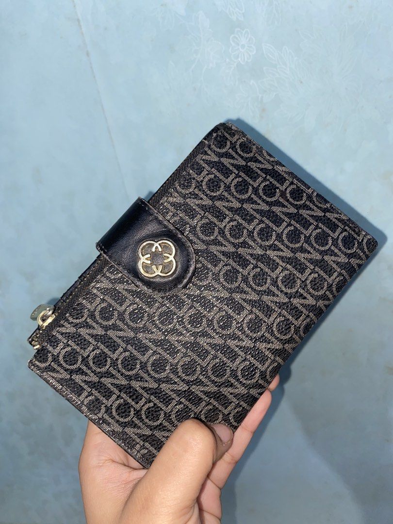 CLN Monogram Medium/Bifold Wallet (Category: Wallets & Card holders) located in Pasig City. Submitted by six_seven67 (Listing ID 1468378663, Image 1). Description: - Stylish black and brown patterned design with a snap button closure and metallic logo detail - Smooth black leather interior lining - Multiple card slots and spacious bill compartments - Convenient clear ID window - Side zippered pocket for coins - Compact size that fits easily into 