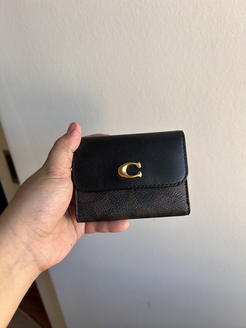 Coach Essential Card Holder Wallet (Category: Luxury Bags & Wallets) located in Quezon City. Submitted by preloved.by.gia (Listing ID 1468339063, Image 1). Description: - Authentic Coach signature canvas and smooth leather tri-fold wallet - Colorway: Dark brown and black with iconic gold-tone C hardware - Secure snap closure on the main flap - Interior features a full bill compartment and multiple card slots - Includes a detachable zip card case 