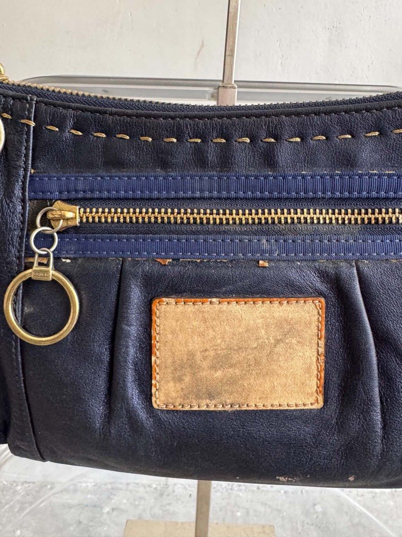 Coach Navy Leather Shoulder Bag (Category: Luxury Bags & Wallets) located in Manila. Submitted by prettyyybagss (Listing ID 1468385306, Image 3). Description: - Brand: Coach - Color: Navy blue leather with contrast stitching - Hardware: Brass tone - Closure: Zip top with front zip pocket and ring pull - Serial Number: D1026-15335 - Condition Notes: Overall exterior wear, significant staining/discoloration on the interior fabric lining, and major 