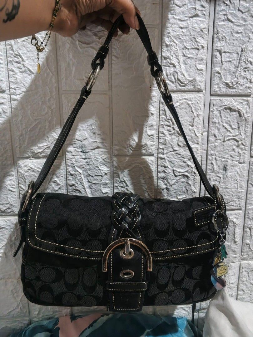 Coach Signature Black Monogram Shoulder Bag (Category: Luxury Bags & Wallets) located in Cabanatuan. Submitted by bagsyoulove (Listing ID 1468314435, Image 1). Description: - Brand: Coach - Style: Signature monogram shoulder bag - Color: Black fabric with dark leather trim - Hardware: Silver-tone throughout - Closure: Front buckle with braided leather strap detail - Accents: Cute charms hanging from the side ring - Interior: Clean and spacious - 