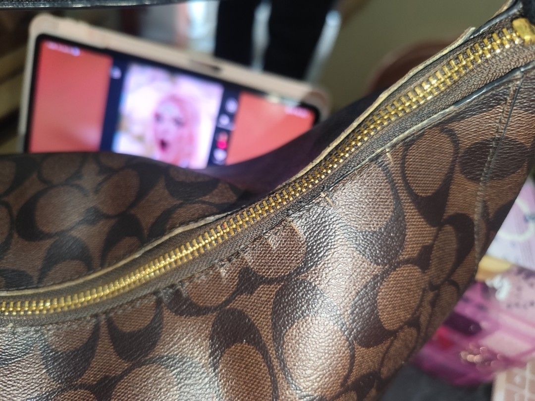 Coach Signature Monogram Shoulder Bag with Cherry Charm (Category: Luxury Bags & Wallets) located in Naga. Submitted by semflewer (Listing ID 1468295320, Image 3). Description: - Brand: Coach - Style: Monogram shoulder bag in brown with dark brown trim - Hardware: Gold-tone - Closure: Zip top - Strap: Black leather shoulder strap (normal wear along edges and seams) - Accents: Cute dangling cherry charm and front metal logo plaque - Condition: Pre