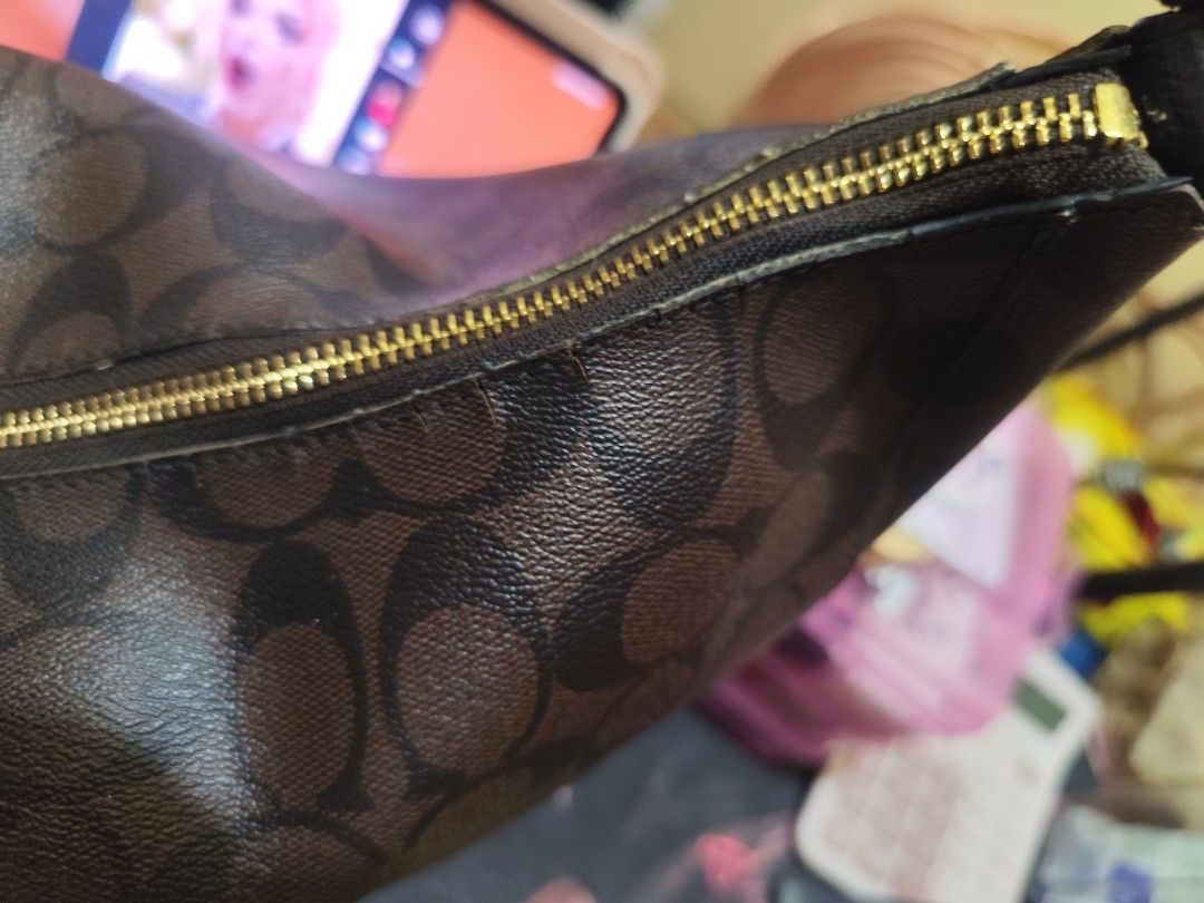 Coach Signature Monogram Shoulder Bag with Cherry Charm (Category: Luxury Bags & Wallets) located in Naga. Submitted by semflewer (Listing ID 1468295320, Image 2). Description: - Brand: Coach - Style: Monogram shoulder bag in brown with dark brown trim - Hardware: Gold-tone - Closure: Zip top - Strap: Black leather shoulder strap (normal wear along edges and seams) - Accents: Cute dangling cherry charm and front metal logo plaque - Condition: Pre