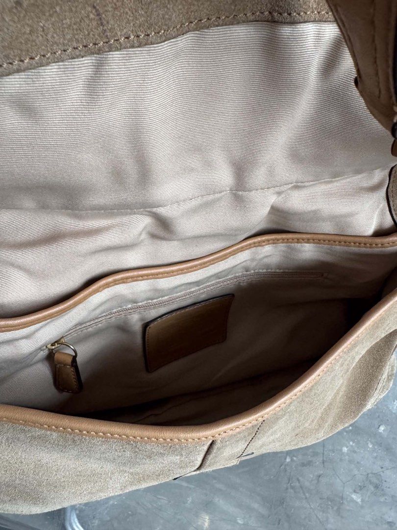Coach Suede Shoulder Bag (Category: Shoulder Bags) located in Manila. Submitted by prettyyybagss (Listing ID 1468385308, Image 2). Description: - Authentic Coach shoulder bag in classic tan suede - Features a bold front buckle closure with brass hardware - Sturdy shoulder strap with secure ring connectors - Fabric-lined interior with a convenient zipper pocket - Includes serial number stamped on the interior leather patch - Condition note: Shows 