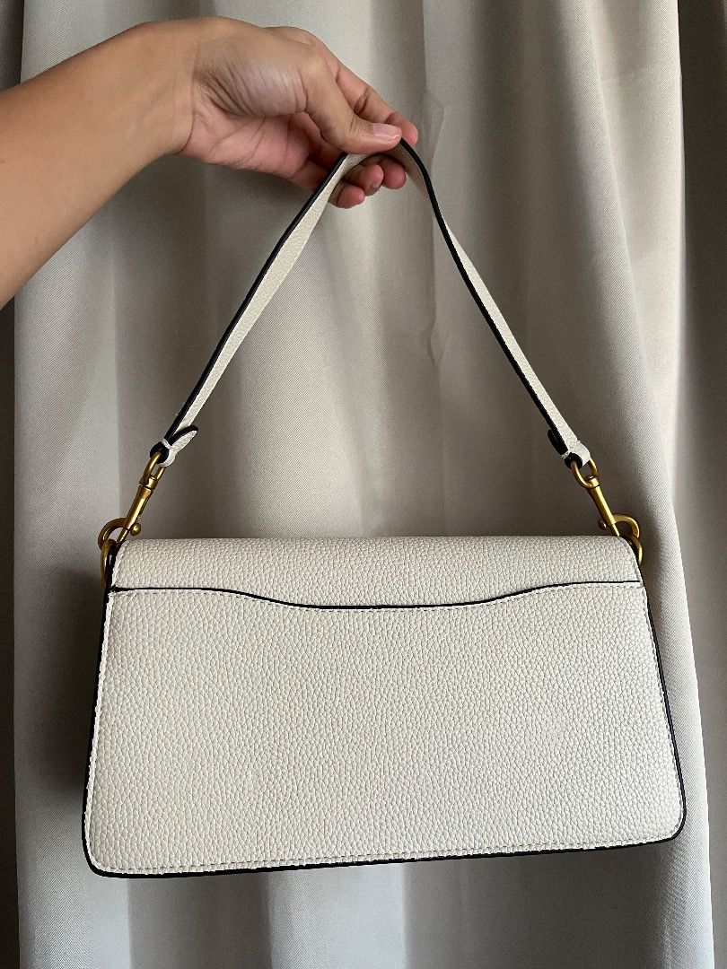 Coach Tabby Shoulder Bag White Brass Hardware (Category: Shoulder Bags) located in Caloocan City. Submitted by safemountain.0b3a05 (Listing ID 1468394426, Image 2). Description: - Authentic Coach Tabby shoulder bag in classic white pebbled leather - Stunning antique brass 'C' closure and hardware - Soft tan suede fabric interior lining - Organized interior with multiple compartments and a central zipped divider - Clean, structured silhouette perf