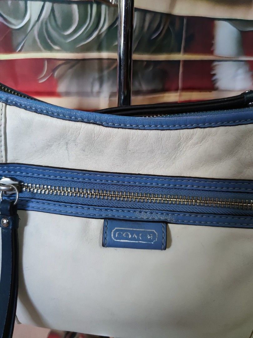 Coach White and Blue Leather Shoulder Bag (Category: Luxury Bags & Wallets) located in Dagupan City. Submitted by jhazrightshop (Listing ID 1468474392, Image 3). Description: - Authentic Coach shoulder bag in white leather with blue trim - Convenient front zipped pocket with a leather pull tab - Includes a matching blue leather hangtag on a beaded chain - Adjustable strap with sleek silver hardware - Detailed interior zipper pull with clear Coach