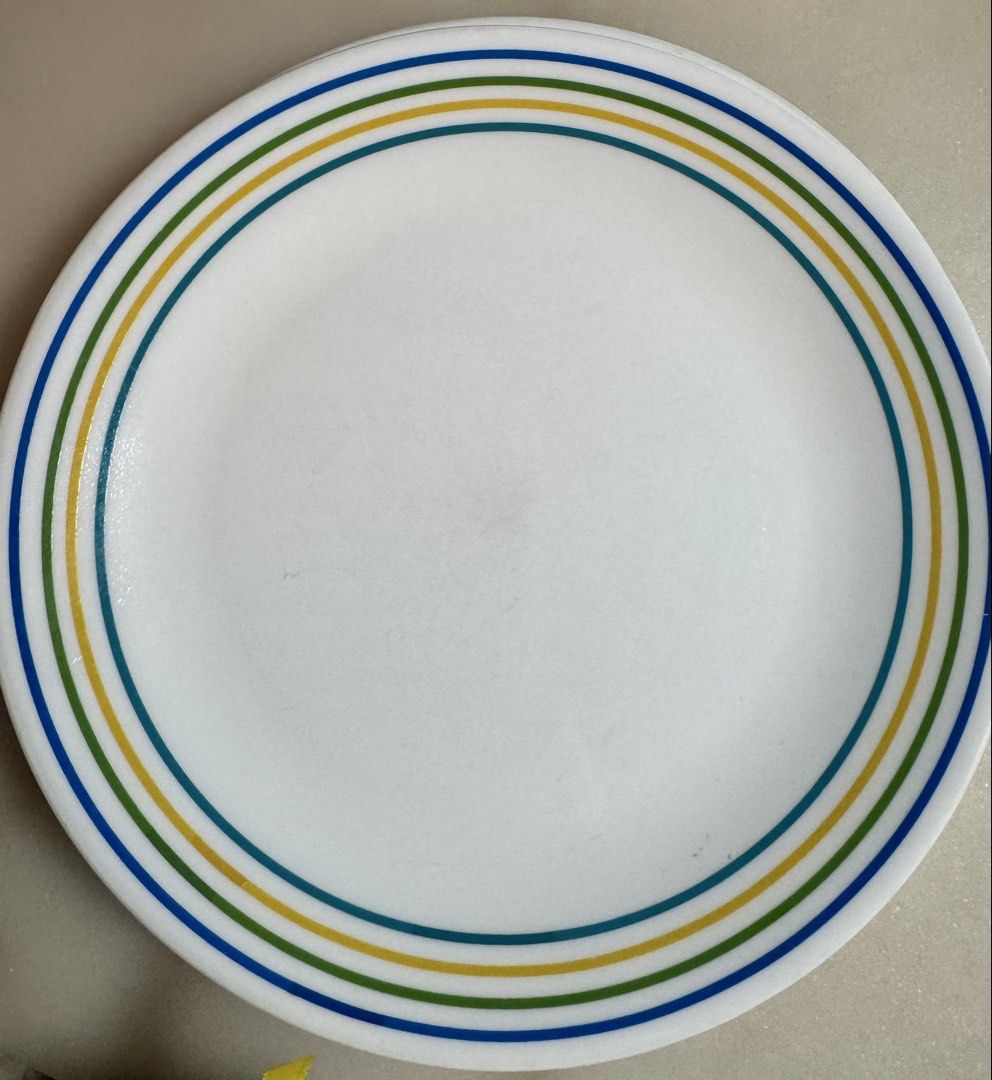 Corelle dinnerware 12 pc set (Category: Dinnerware & Cutlery) located in Paranaque City. Submitted by tripleddd151025 (Listing ID 1468299566, Image 2). Description: 4 pcs dinner plate 4 pcs dessert plate 4 pcs serving bowl - Set includes white ceramic plates and a bowl with colorful blue, green, and yellow rings - Classic and simple design, perfect for daily meals and hosting guests - Smooth and easy-to-clean glossy finish - Microwave and dishwas