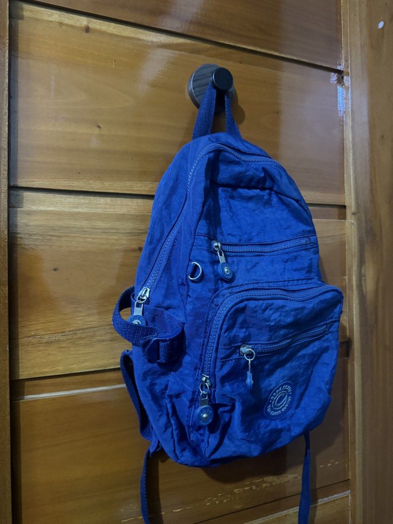 Cosé Style Blue Nylon Multi-Pocket Mini Backpack (Category: Backpacks) located in Baguio. Submitted by heath2600 (Listing ID 1468437402, Image 2). Description: - Brand: Cosé Style - Color: Deep blue - Material: Durable nylon - Pockets: Multiple zipped compartments on the front for easy organization - Hardware: Silver-toned zippers with matching round zipper pulls - Details: Circular brand logo patch near the bottom pocket - Comfort: Adjustable sh