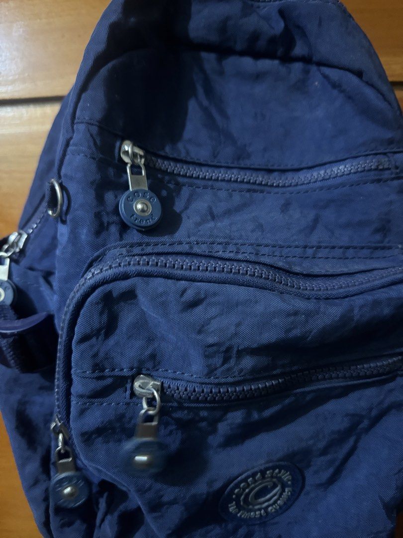 Cosé Style Blue Nylon Multi-Pocket Mini Backpack (Category: Backpacks) located in Baguio. Submitted by heath2600 (Listing ID 1468437402, Image 3). Description: - Brand: Cosé Style - Color: Deep blue - Material: Durable nylon - Pockets: Multiple zipped compartments on the front for easy organization - Hardware: Silver-toned zippers with matching round zipper pulls - Details: Circular brand logo patch near the bottom pocket - Comfort: Adjustable sh