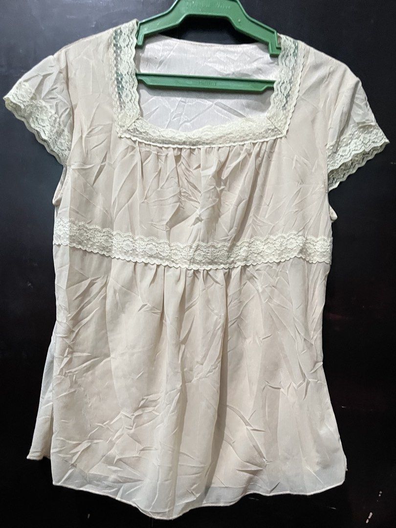 Cream Laced Milkmaid Top (Category: Blouses) located in Talisay. Submitted by kitsaidy (Listing ID 1468326816, Image 1). Description: - Color: Cream - Design: Square neckline, short sleeves, empire waist with gathering - Details: Delicate lace trim on collar, sleeves, and midsection - Fabric: Lightweight (note: slightly wrinkled from storage) - Styling: Easy to pair with high-waisted jeans or skirts for everyday wear.