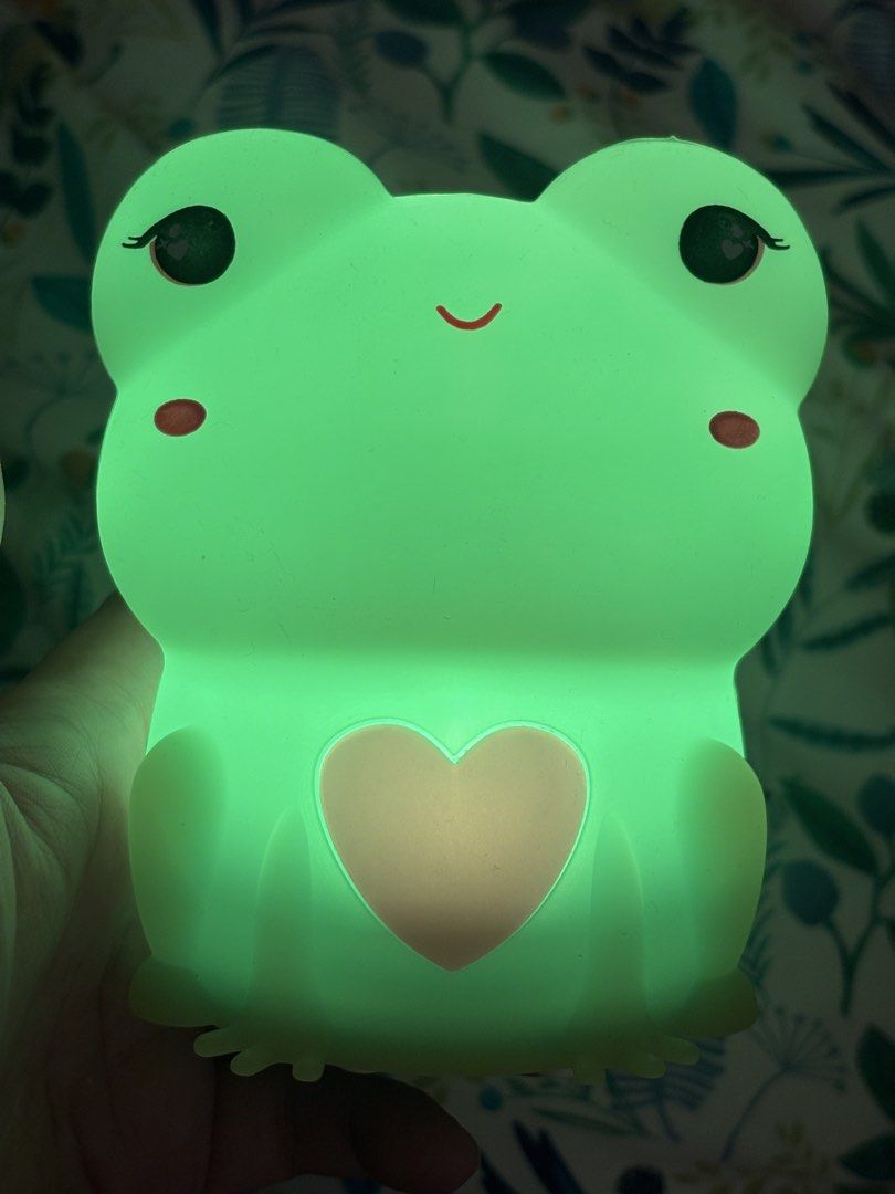 Cute frog silicone night light with color changing LED (Category: Lighting) located in Antipolo. Submitted by annesmarket (Listing ID 1468358705, Image 1). Description: - Adorable frog night light made from soft, touchable silicone - Features sweet sleeping eyes and a cute pink heart on the belly - Glows in multiple vibrant colors (green, red, yellow, and more) - Convenient battery-operated design for easy placement anywhere - Charming decor piec