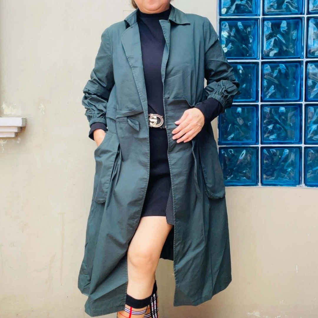 Dark Green Long Trench Coat Jacket (Category: Coats, Jackets and Outerwear) located in Bulacan. Submitted by fenph2021 (Listing ID 1468305344, Image 1). Description: - Color: Dark green - Style: Open front midi trench coat with tie waist belt - Fabric: Lightweight, great for layering - Features: Lapel collar, long sleeves with gathered cuffs, and large front pockets - Length: Midi (falls past the knees) - Perfect for: Cooler weather and effortles