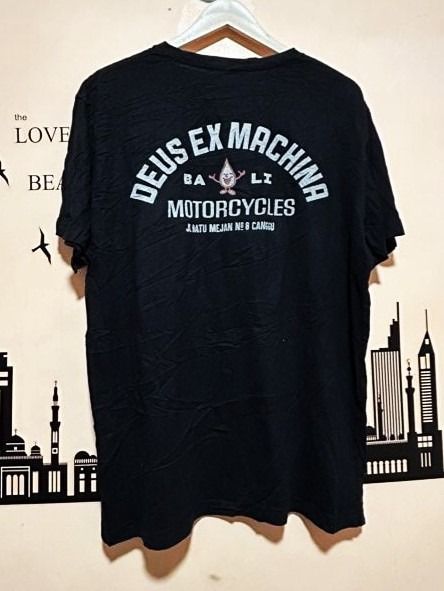 Deus Ex Machina Bali Classics (Dimes: 23W 28L) (Category: Tshirts & Polo Shirts ) located in General Santos City (Dadiangas). Submitted by moana_thrifts (Listing ID 1467926441, Image 1). Description: - Brand: Deus Ex Machina - Color: Black - Size: XL (Regular fit, standard crew neck) - Material: 100% Organic Cotton (Made in Indonesia) - Design: Small front chest graphic, large Bali Canggu print on the back - Authenticity: Includes interior CertiE