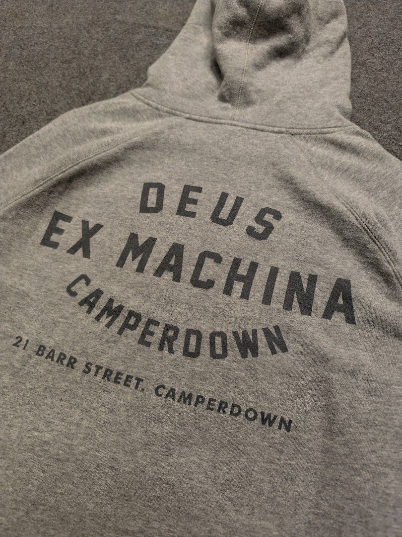 Deus Ex Machina Camperdown Cotton Hoodie (Category: Hoodies) located in Cordova. Submitted by bsb.streetluxvintage.clothing (Listing ID 1468424391, Image 3). Description: - Brand: Deus Ex Machina - Size: Medium - Color: Classic heather grey - Design: Small shield logo on chest; large 'Deus Ex Machina Camperdown' lettering with '21 Barr Street' address on back - Features: Adjustable drawstring hood and front kangaroo pocket - Material: Soft and wa