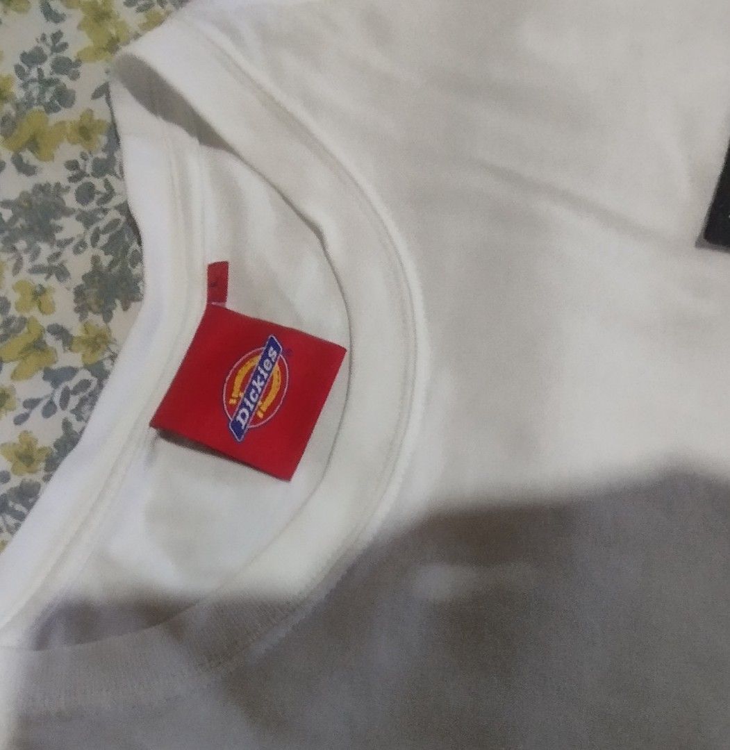 Dickies White T-Shirt Size L (Category: Tshirts & Polo Shirts ) located in Manila. Submitted by lene48 (Listing ID 1468326445, Image 2). Description: - Brand: Dickies - Color: Solid White - Size: L - Material: 100% Cotton - Details: Small black chest logo patch, red neck label, and small hem tag - Condition/Use: Clean basic tee, perfect for daily wear.