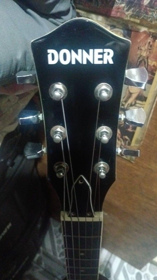 Donner Electric Guitar Black Single Cutaway (Category: Musical Instruments) located in Manila. Submitted by cosmicdeer.c5ba23 (Listing ID 1468414292, Image 2). Description: - Brand/Model: Donner electric guitar in classic black finish - Body & Pickups: Single cutaway shape loaded with dual humbucker pickups - Hardware & Controls: Chrome hardware, volume and tone knobs, and pickup selector switch - Neck & Fretboard: Standard fretboard featuring cl