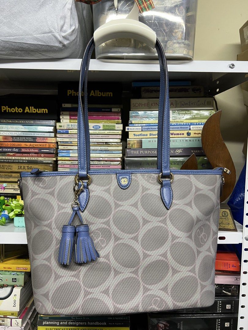Elegance Blue and Gray Tote Bag (Category: Tote Bags) located in Manila. Submitted by apoltree (Listing ID 1468440096, Image 1). Description: - Brand: Elegance - Color: Blue and gray with blue leather trim - Design: Perforated circular pattern across the body with matching double tassels - Hardware: Gold-tone - Closure: Top zipper - Pockets: Exterior zipper pocket on the back - Condition: Clean interior and well-maintained structured shape -with 