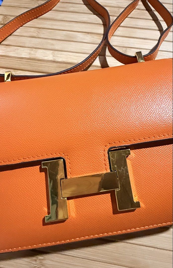 Constance Flap Bag in Vibrant Orange (Gold Hardware) (Category: Cross-body Bags) located in Caloocan City. Submitted by shnicky101 (Listing ID 1468488981, Image 2). Description: Style: Constance Flap Shoulder Bag Color: Signature Orange (Feu) Hardware: Gold-Tone Hardware Material: Textured Epsom-Style Leather Condition: Preloved. Received as a gift and clearing out unutilized wardrobe pieces! Selling as-is at a budget-friendly price..