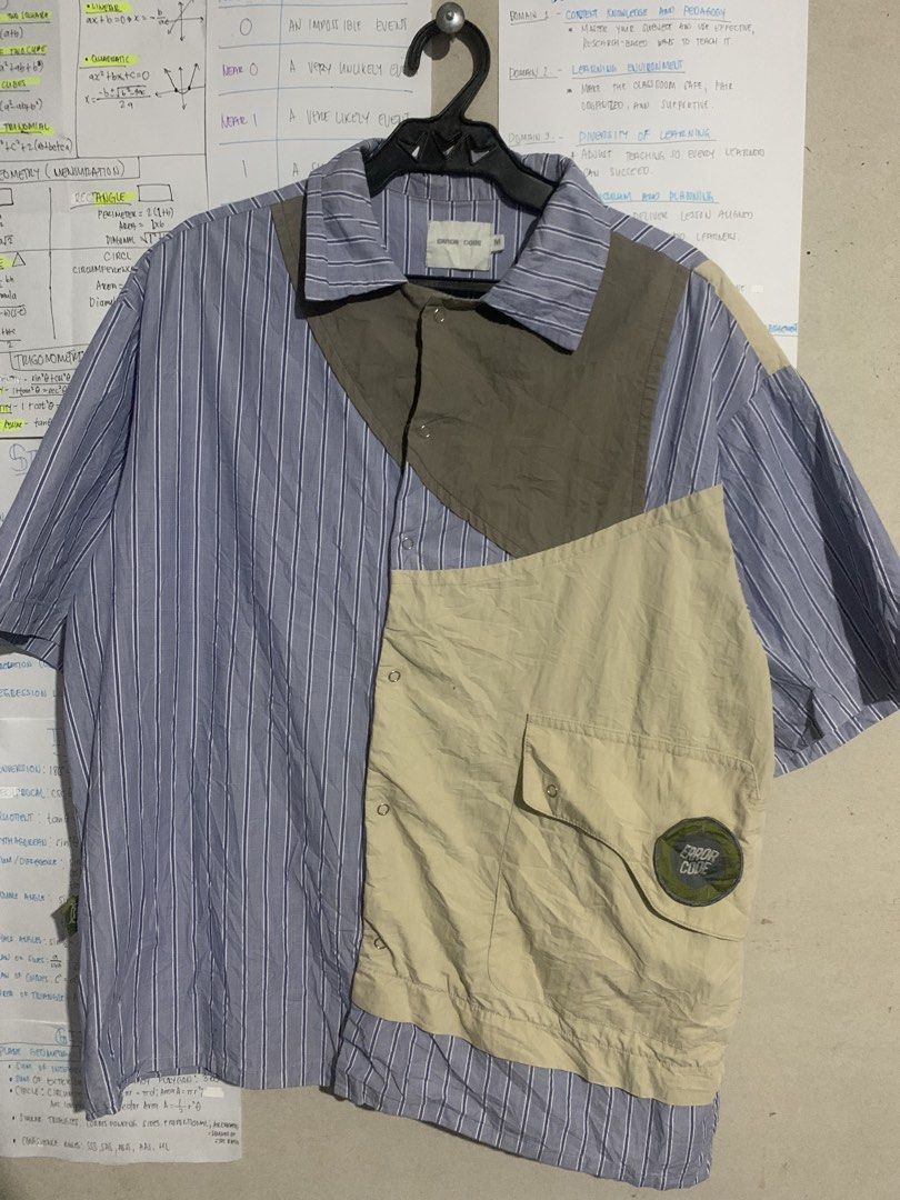ERROR CODE Colorblock Striped Short Sleeve Shirt Size M (Category: Tshirts & Polo Shirts ) located in Naga. Submitted by than09070539101 (Listing ID 1468384912, Image 1). Description: - Brand: ERROR CODE - Size: Medium (tag on inside neck) - Design: Unique colorblock with blue/white stripes, olive, and beige panels - Details: Asymmetric front pocket with circular embroidered logo patch, regular collar, short sleeves - Style: Statement piece with 