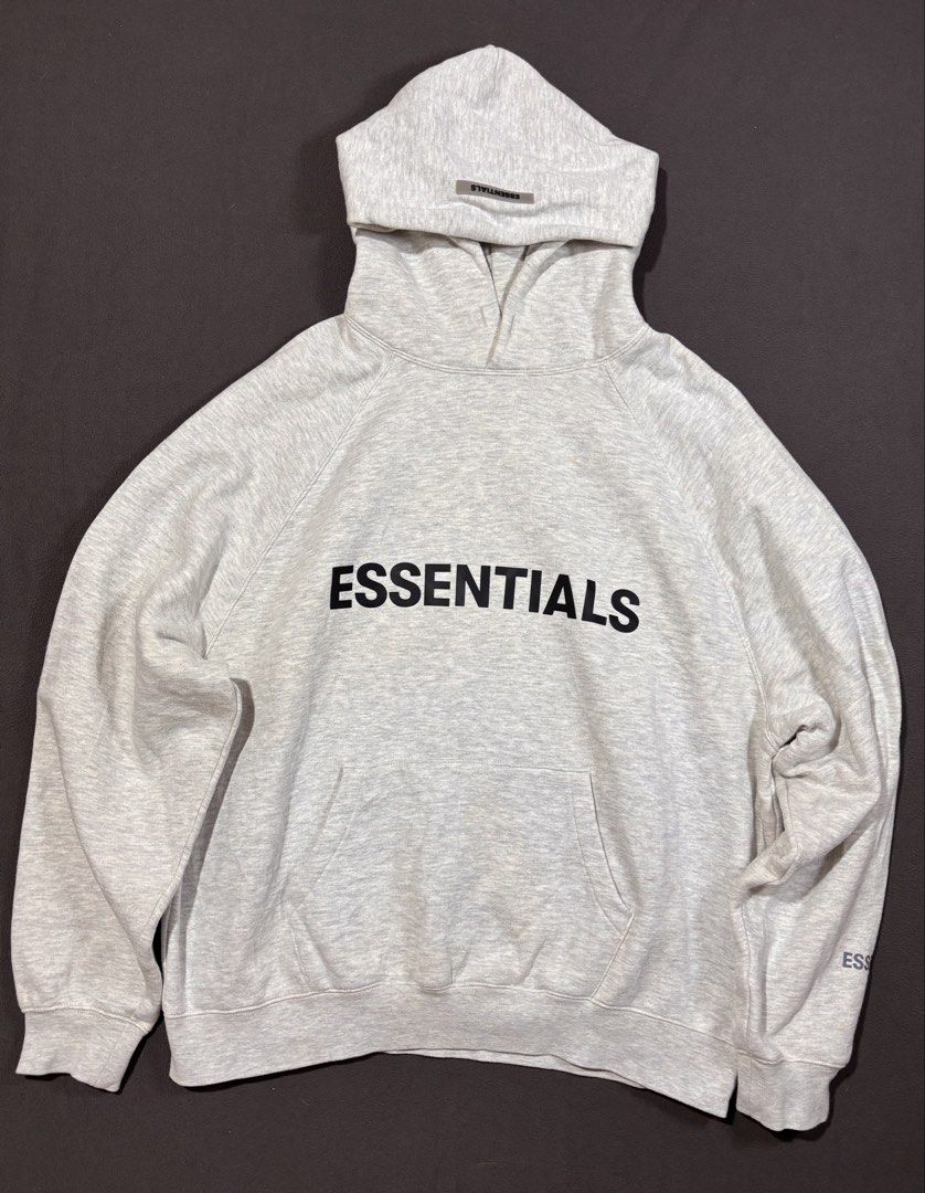 Essentials Grey pull over hoodie (Category: Hoodies) located in Mabalacat. Submitted by _limitlessfashion (Listing ID 1468299357, Image 1). Description: - Brand/Model: Fear of God Essentials Hoodie - Color: Light Grey Melange - Size medium on tag - Length 27 - Width 26.5 - Color rate 9.5 - Issue minimal washable yellow stain - Fit: Classic oversized fit - Details: Black chest branding, rubberized hood patch, sleeve text print, and kangaroo pocket