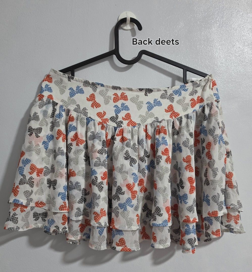 Etam Weekend Bow Pattern Layered Skirt Size 40 (Category: Skirts) located in Paranaque City. Submitted by franinnashop (Listing ID 1468361474, Image 3). Description: Declutter - Brand: Etam Weekend - Design: White skirt with red, blue, and grey bow prints, layered ruffle multi-tier design - Size: Tagged Size 40 (Width: 30 inches, Length: 13 inches) - Material: Lightweight chiffon-like fabric with side zipper closure - Style: Fun, playful, and eas