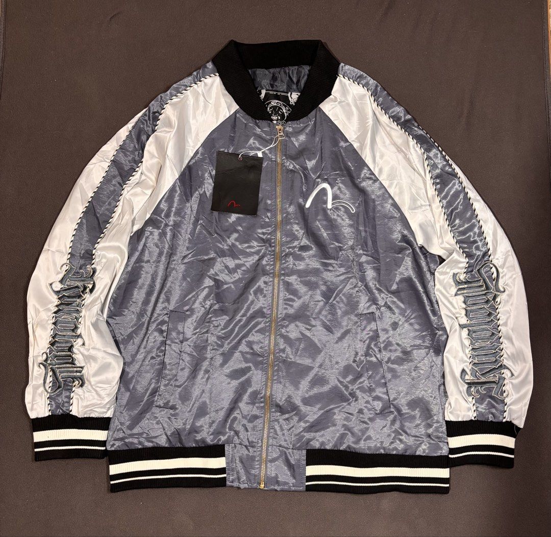 Evisu Kuro Bomber Jacket Grey White (Category: Coats, Jackets and Outerwear) located in Mabalacat. Submitted by _limitlessfashion (Listing ID 1468305398, Image 1). Description: - Brand: Evisu Kuro - Style: Bomber jacket in grey and white satin finish - Size large on tag - Length 27 - Width 23 - No issue, bnew condition - Condition: Brand new with tags still hanging from the zipper pull - Details: Full zip front, striped ribbed collar, cuffs, and 