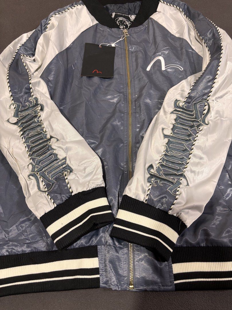 Evisu Kuro Bomber Jacket Grey White (Category: Coats, Jackets and Outerwear) located in Mabalacat. Submitted by _limitlessfashion (Listing ID 1468305398, Image 2). Description: - Brand: Evisu Kuro - Style: Bomber jacket in grey and white satin finish - Size large on tag - Length 27 - Width 23 - No issue, bnew condition - Condition: Brand new with tags still hanging from the zipper pull - Details: Full zip front, striped ribbed collar, cuffs, and 