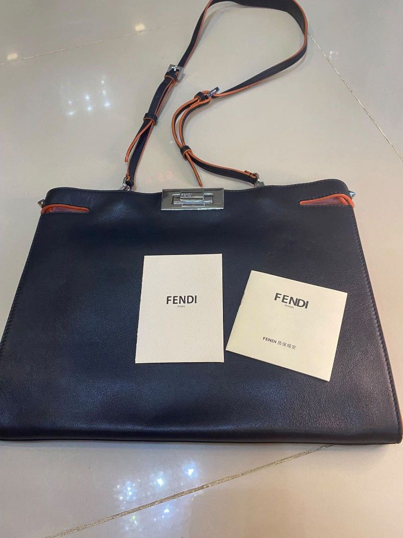 Fendi Leather Shoulder Bag with Orange Trim (Category: Luxury Bags & Wallets) located in Manila. Submitted by boldfire_315559 (Listing ID 1468303341, Image 1). Description: - Authentic Fendi shoulder bag in classic black leather - Eye-catching bright orange trim details along the straps and edges - Secure silver-tone hardware lock closure engraved with the iconic Fendi logo - Luxurious pink leather interior lining with a 'Made in Italy' metal log