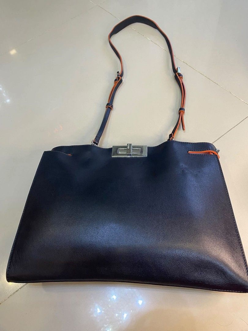 Fendi Leather Shoulder Bag with Orange Trim (Category: Luxury Bags & Wallets) located in Manila. Submitted by boldfire_315559 (Listing ID 1468303341, Image 2). Description: - Authentic Fendi shoulder bag in classic black leather - Eye-catching bright orange trim details along the straps and edges - Secure silver-tone hardware lock closure engraved with the iconic Fendi logo - Luxurious pink leather interior lining with a 'Made in Italy' metal log