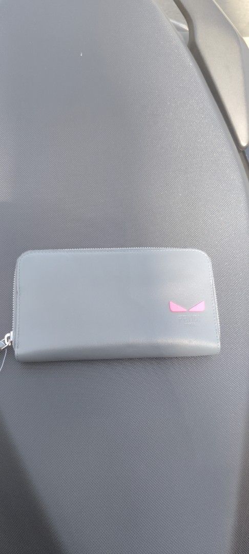 Fendi Zip Around Wallet Gray Pink Eyes (Category: Wallets & Card holders) located in San Mateo. Submitted by roxyj120919 (Listing ID 1468295571, Image 1). Description: - Authentic Fendi zip around wallet (Style code: 7M0267) - Color: Tempesta gray leather with striking pink eyes motif and contrast pink interior trim - Hardware: Silver-tone - Interior: Multiple card slots, slip compartments, and a secure zippered coin pocket - Inclusions: Original