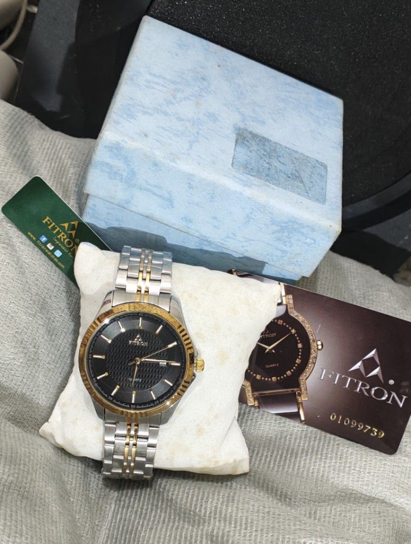 Fitron Quartz Two-Tone Men's Watch 9193M (Category: Men's Watches) located in Manila. Submitted by burgerpatti (Listing ID 1468462941, Image 1). Description: - Brand: Fitron Japan Quartz Watch (Model 9193M) - Design: Textured dark dial with gold bezel and date window at 3 o'clock - Strap: Two-tone silver and gold stainless steel bracelet - Build: Stainless steel back, water resistant - Inclusions: Complete with original blue box, tags, and produc