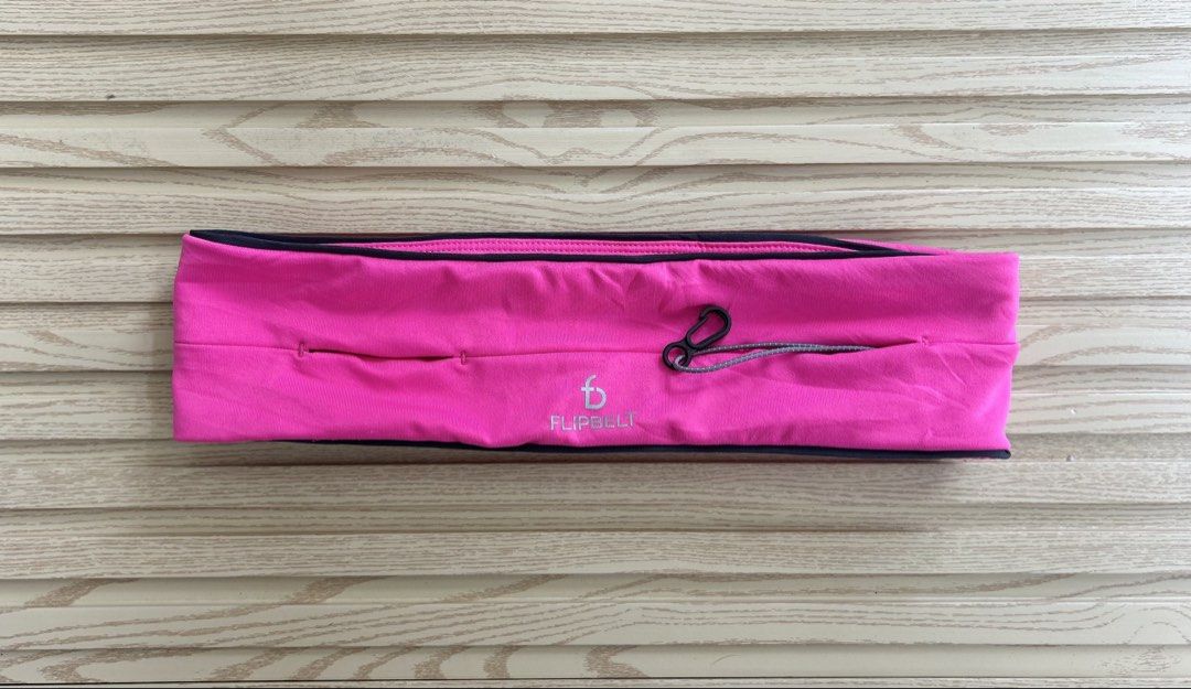 FlipBelt Pink Running Belt with Key Hook (Category: Activewear) located in Cagayan de Oro. Submitted by aljay02 (Listing ID 1468392735, Image 2). Description: - Color: Bright pink with silver reflective branding - Size: 14 to 15 inches flat across (unstretched with great stretch) - Storage: Multiple secure slit pockets for phone and essentials - Extras: Attached black key hook on an elastic cord - Condition: Clean fabric, perfect for hands-free r