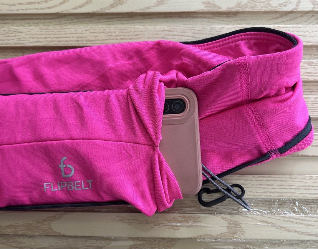 FlipBelt Pink Running Belt with Key Hook (Category: Activewear) located in Cagayan de Oro. Submitted by aljay02 (Listing ID 1468392735, Image 3). Description: - Color: Bright pink with silver reflective branding - Size: 14 to 15 inches flat across (unstretched with great stretch) - Storage: Multiple secure slit pockets for phone and essentials - Extras: Attached black key hook on an elastic cord - Condition: Clean fabric, perfect for hands-free r