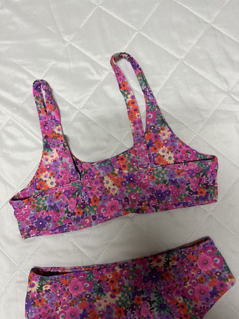 Floral Print Two-Piece Bikini High-Waisted (Category: Bikinis & Swimsuits) located in Valenzuela. Submitted by prelovedbyramsie (Listing ID 1468409508, Image 3). Description: - Style: Two-piece bikini set with high-waisted bottoms and a scoop neck crop top - Design: Vibrant floral pattern in purple, pink, and orange - Features: Adjustable straps for a customized fit and flattering cut - Material: Stretchy, comfortable swim fabric - Condition: Cle