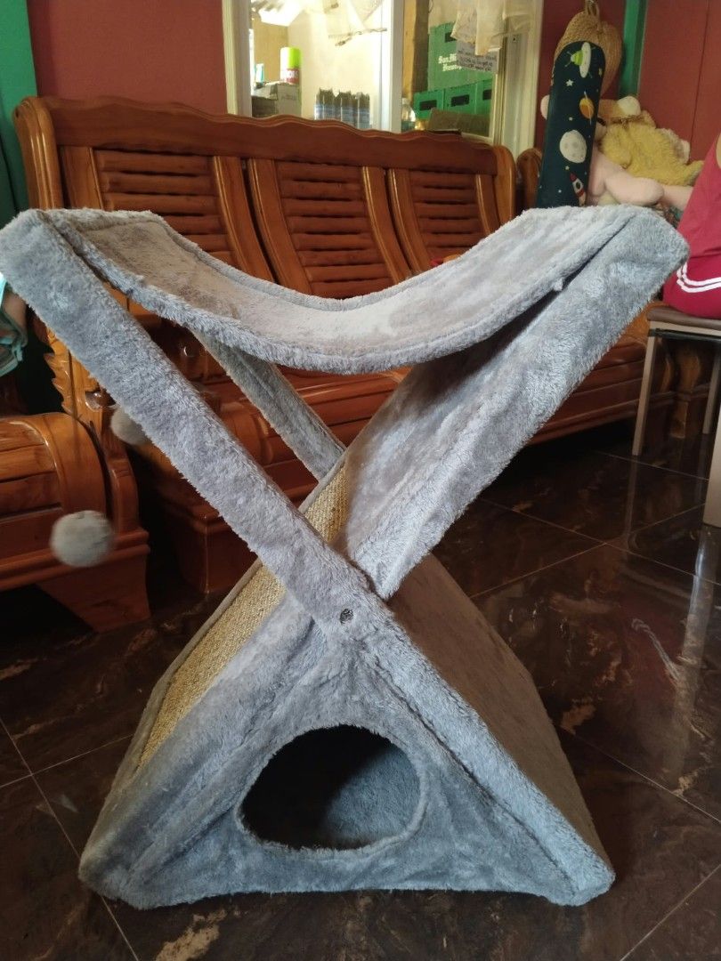 Foldable Gray Cat Scratching Post with Condo and Toys (Category: Homes & Other Pet Accessories) located in Samboan. Submitted by stephie_89 (Listing ID 1468304423, Image 1). Description: - Color: Gray - Features a triangular cave, central scratching pad, hanging pom-pom toys, and a top lounging hammock - X-frame design folds down completely flat for easy storage - Wrapped in soft, cozy plush fabric - Built with a sturdy wooden backing on the top 
