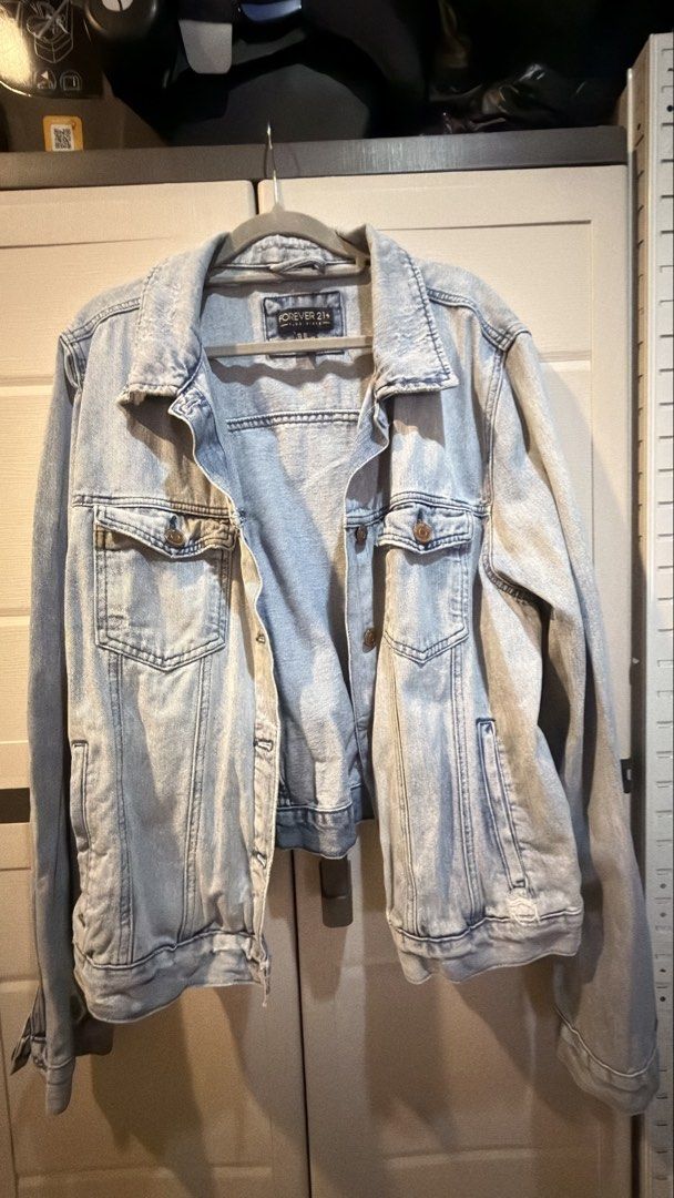 Forever 21 Light Wash Distressed Denim Jacket Plus Size (Category: Coats, Jackets and Outerwear) located in Manila. Submitted by adoptmypreloveditems (Listing ID 1468477727, Image 2). Description: - Brand: Forever 21 (Plus Size) - Style: Light wash denim jacket with distressed details on the back and hem - Features: Button-up front, classic collar, dual chest pockets, and side pockets - Fit: Comfortable plus size fit, great for layering on cooler