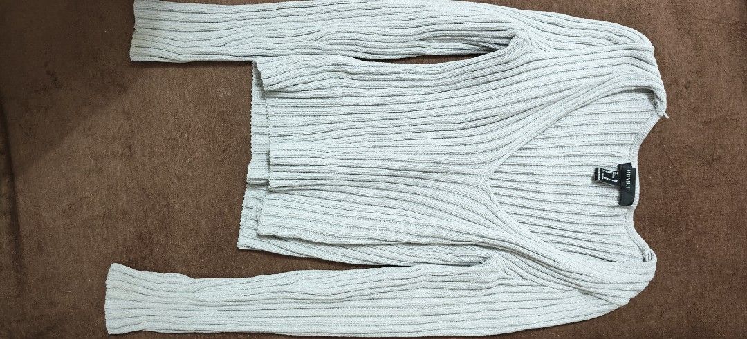 Forever 21 Ribbed Knit V-Neck Sweater (Category: Longsleeves) located in Manila. Submitted by snz_shop (Listing ID 1468459933, Image 1). Description: - Brand: Forever 21 - Color: Light Grey - Size: Medium (M) - Material/Texture: Cozy ribbed knit with vertical texturing - Design: Deep V-neckline and long sleeves - Condition: Excellent pre-loved condition / Brand new options available - Perfect for: Casual days, layering, and chic minimalist outfit