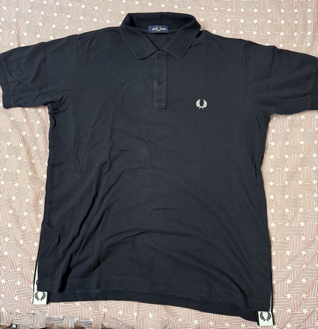 Fred Perry Black Polo Shirt Size L (Category: Tshirts & Polo Shirts ) located in Quezon City. Submitted by apm269 (Listing ID 1468295628, Image 1). Description: - Brand: Fred Perry - Color: Solid Black - Size: L (Tag on collar) - Material: 100% Cotton body - Details: Classic embroidered laurel wreath logo on the chest, button placket, and side slits with laurel tape detail near the hem - Condition: Clean fabric finish with care tag intact - width