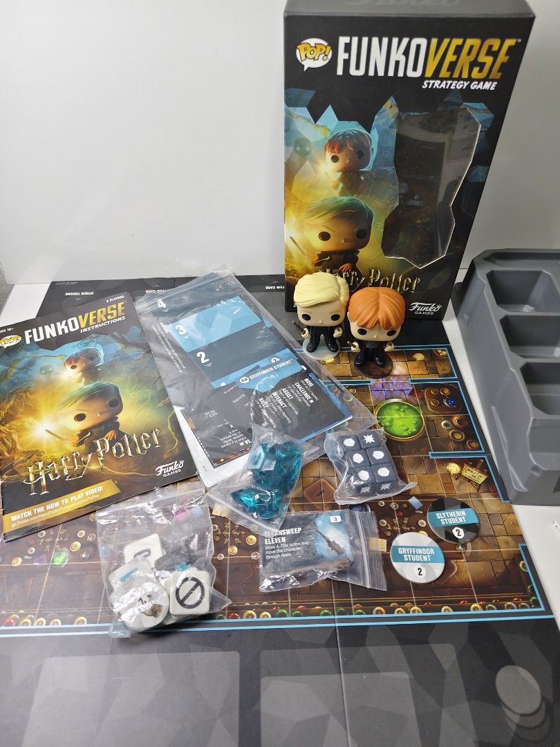 FunkoVerse Harry Potter Strategy Game (Category: Board Games & Puzzles) located in Las Pinas. Submitted by mommy_14 (Listing ID 1468378419, Image 2). Description: - Game: FunkoVerse Strategy Board Game - Harry Potter Theme - Players: 2 players, ages 10 and up - Condition: Unboxed, complete set, neatly laid out - Inclusions: Draco Malfoy and Ron Weasley figures, game board, instructions, dice, tokens, and cards - Perfect for: Fun game nights with 