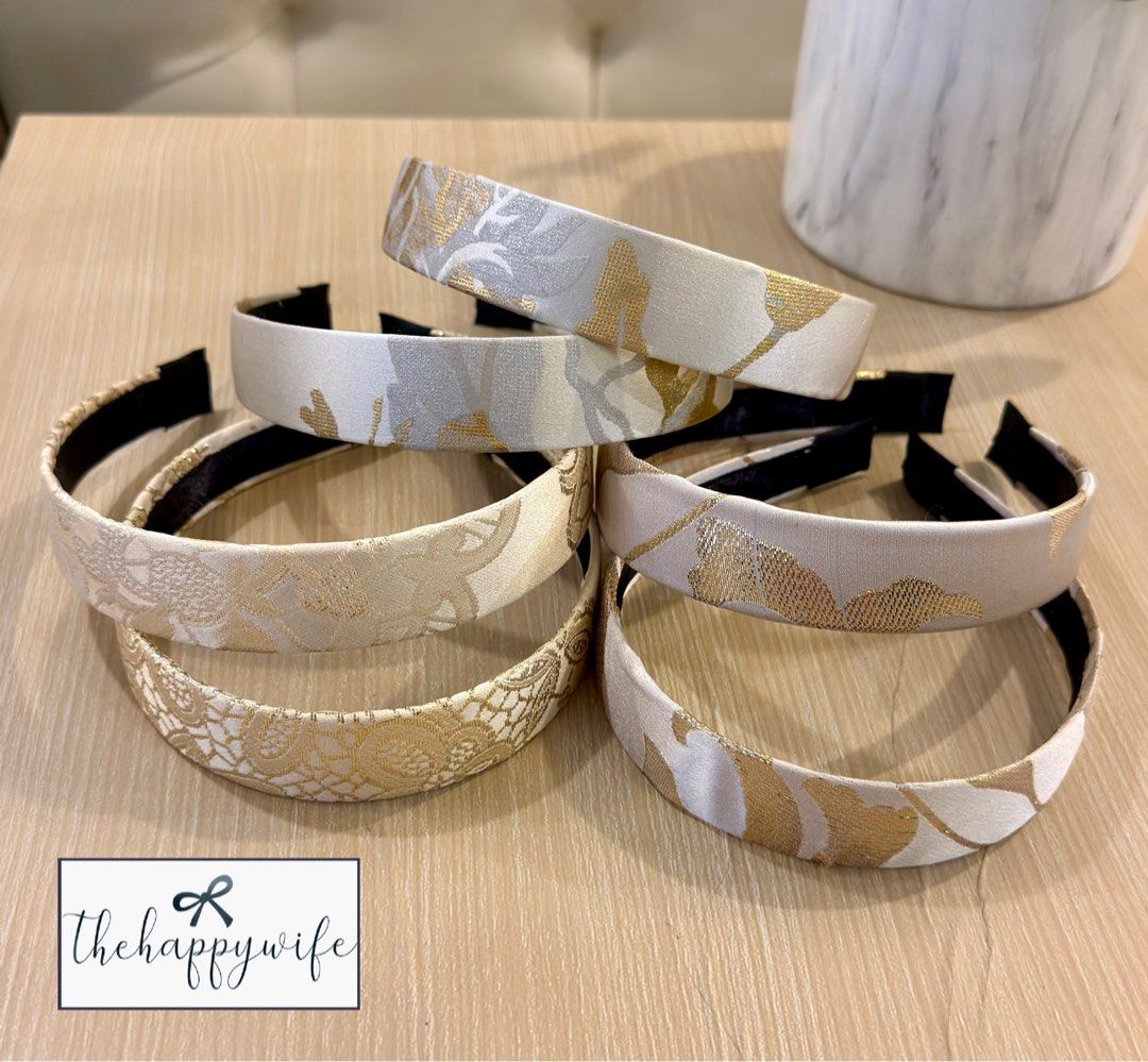 Gold and beige patterned fabric hairband (Category: Hair Accessories) located in Makati City. Submitted by thehappywife (Listing ID 1468292431, Image 1). Description: - Color: Gold and beige with a soft sheen - Design: Detailed patterned weave - Comfort: Flexible band with soft black fabric wrapping at the ends - Versatility: Perfect accessory for casual everyday wear or special outfits - Condition: Brand new / Excellent quality - Sold per piece.