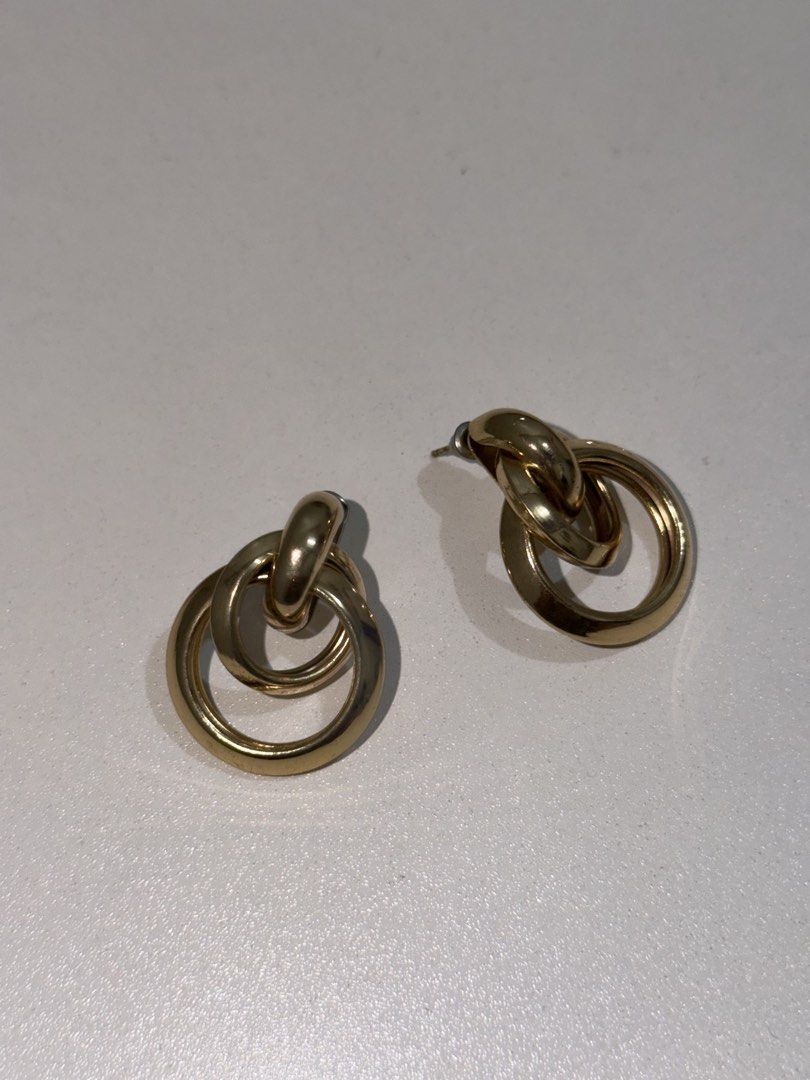Gold interlocking hoop earrings (Category: Earrings) located in Taguig. Submitted by deguzmanke83356 (Listing ID 1468325794, Image 1). Description: - Gold-tone finish - Interlocking double hoop design - Lightweight metal for all-day comfort - Secure post back closure - Versatile minimalist style for casual or formal wear.