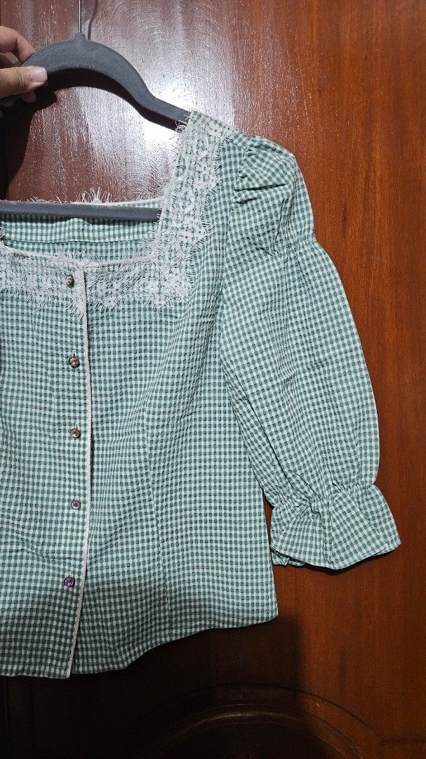 Green White Gingham Check Blouse with Lace Trim (Category: Blouses) located in Quezon City. Submitted by tiamaureia (Listing ID 1468390899, Image 2). Description: - Green and white gingham check blouse with square neckline. - Detailed with white lace trim along the collar and front placket. - Long sleeves with ruffled cuffs. - Buttons down the front with rhinestone embellishments. .