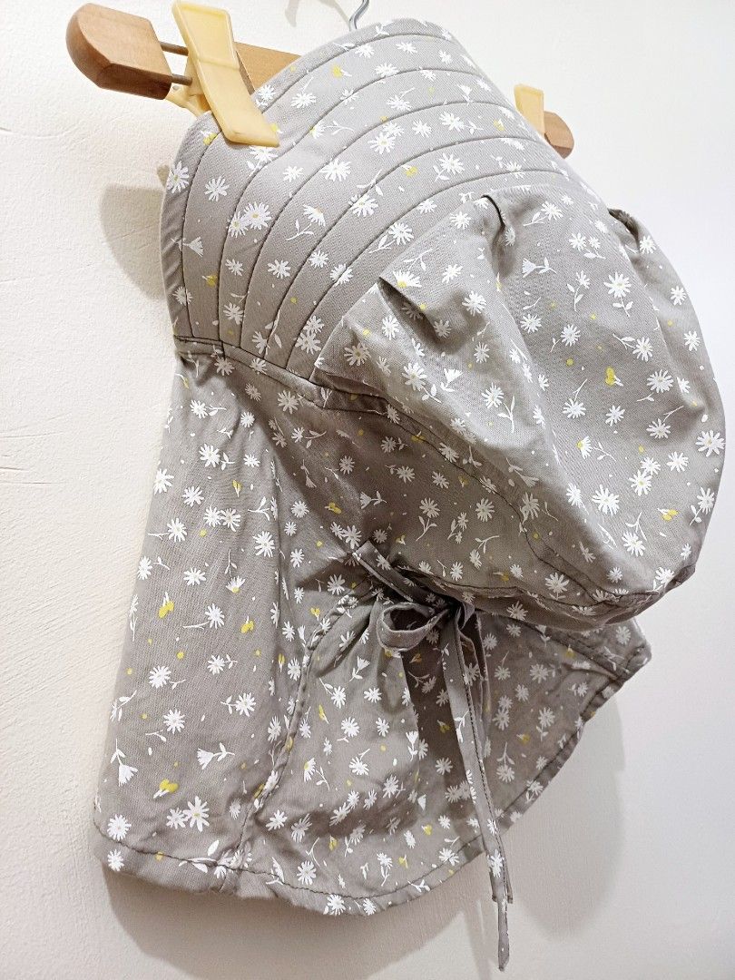 Grey Floral Sun Hat With Neck Flap (Category: Hats & Beanies) located in Pasig City. Submitted by eden_online_shop (Listing ID 1468357954, Image 3). Description: - Color & Pattern: Grey with all-over small white flowers and yellow details - Sun Protection: Wide brim and long neck flap to block harmful rays - Easy Closure: Convenient front velcro closure for quick wear - Secure Fit: Ties underneath keep the hat safely in place - Condition: Like ne